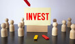 © Uladzislau - invest word written on white business card