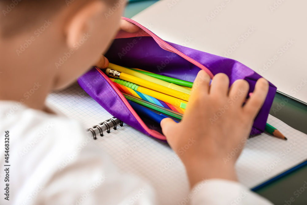 Little boy with pencil case at home, closeup