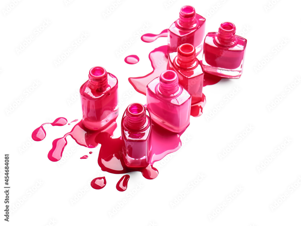 Opened bottles with spilled nail polishes on white background