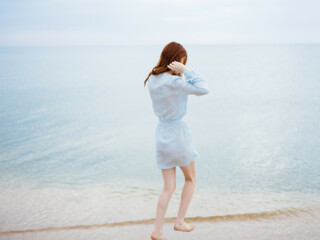 Wall Mural - woman in dress walking along the beach island ocean landscape