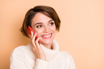 Wall Mural - Photo portrait of female student looking copyspace talking on cellphone smiling isolated on pastel beige color background