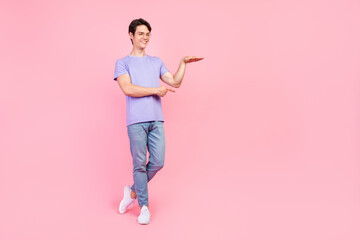 Wall Mural - Full length body size view of attractive cheerful guy showing copy empty space size isolated over pink pastel color background