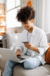 © (JLco) Julia Amaral - Cheerful young woman going on an online shopping spree