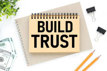 Build Trust, text on white notepad paper. on a white photo with torn paper