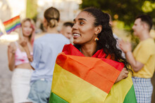 Black Woman Smiling And Holding Rainbow Flag During Pride Parade