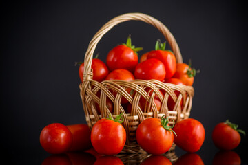 Wall Mural - fresh ripe red tomatoes in basket isolated on black