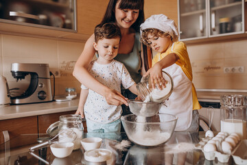 Mother baking with her sons at kitchen