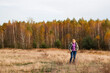 © tanitost - Defocus happy blond 40s woman standing in yellow autumn forest nature background. Happy beautiful lady. Women wearing purple sweater. Fall park, leaves. Dry grass, meadow. Out of focus