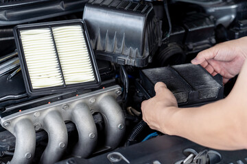 Hand a man holding old air filter of car engine and change new part and check of car in the engine room basic car service concept