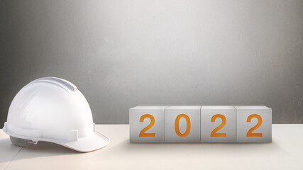 Wall Mural - Happy New Year 2022 Construction and Industry.White Helmet and a numbered concrete cube on the desk of an engineer or construction worker.