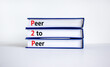 P2P, peer to peer symbol. Books with concept words 'P2P, peer to peer'. Beautiful white background, copy space. Business and P2P, peer to peer concept.