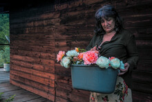 Senior Woman Holding Flowers In Bucket