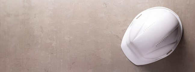 Canvas Print - Construction helmet on gray table background texture. Hardhat at concrete floor