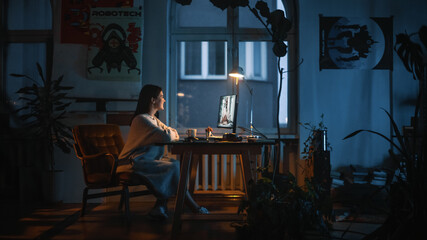 Young Beautiful Female Having a Conference Video Call Meeting on Desktop Computer in Creative Agency in Dark Loft Office. Renovated Stylish Design with House Plants, Posters and Rounded Windows.