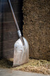 Shovel for a pile of cattle feed alfalfa in a cattle shed