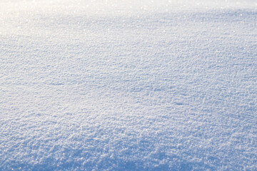 Snowy background, snowy surface with a clearly expressed texture of snow in the morning sun