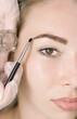 © Ксенич Шитовкина - Young woman correcting eyebrow shape with brush, closeup