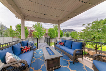 Wall Mural - Cozy outdoor deck with fire pit table and woven sofas with blue cushions