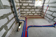 Red and blue pipes of the water supply and heating system in a country house under construction. Installation of a water supply system in a country house
