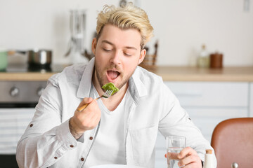 Sticker - Young man eating tasty ravioli at home