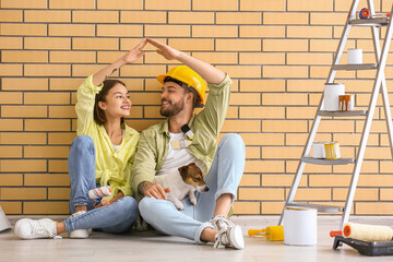 Sticker - Young couple with cute dog resting during repair in their new house