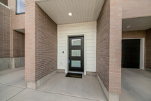 Entrance Of A Townhouse With Lockbox On The Black Door With Glass Panels