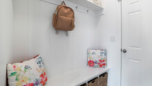 Pano Interior Of A White Mud Room With White Door, Built-in White Bench And Wall Mounted Hooks And Shelf