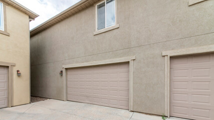 Wall Mural - Pano Exterior of two buildings with concrete driveway, garage doors and windows