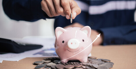 Man hand putting money coin into piggy for saving money wealth and financial concept.