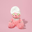 Creative layout with pink teddy bear with towel turban, cucumber slices and luxury jewelry on pastel pink background. 80s or 90s retro fashion aesthetic or cosmetic salon concept. Valentines day idea.