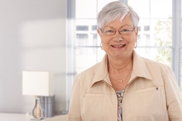 Canvas Print - Closeup portrait of mature woman smiling happy, looking at camera.