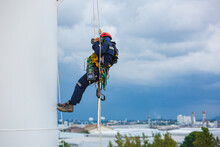 Close-up Male Workers Control Equipment Rope Down Tank Rope Access Background Cloud Storm.