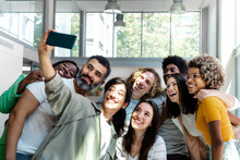 Group Of Multiracial Coworker Friends Take A Selfie In The Office During Work Break. Copy Space.