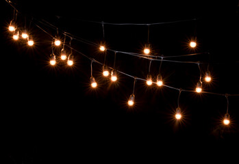 Wall Mural - Garlands of lamps over dark texture