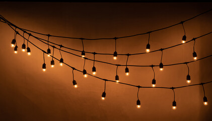 Wall Mural - Garlands of lamps over dark texture