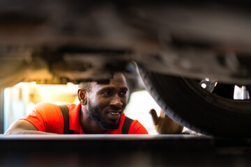 Sticker - Black man mechanic working Under a Vehicle in a Car Service station. Expertise mechanic working in automobile repair garage.