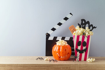 Wall Mural - Horror movie night and Halloween party concept with jack o lantern pumpkin,  popcorn and movie clapperboard on wooden table