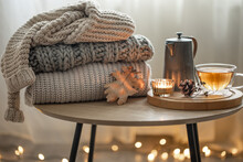 Cozy Autumn Composition With A Cup Of Tea And A Stack Of Knitted Sweaters.