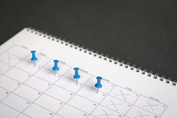 blue pins on four days in a week on a calendar. friday, saturday and sunday crossed out. four day wo