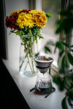 Pour Over Coffee Brewer Between Flowers By The Window