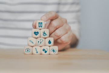 Canvas Print - senior woman's hand arranging medical and health wooden block for wellness, wellbeing after retirement, medical and health insurance concept