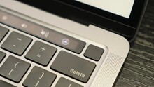 Man unlocking laptop computer with touch ID. Fingerprint sensor on computer