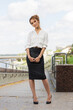 Young fashion business woman in white shirt and pencil skirt with clutch bag