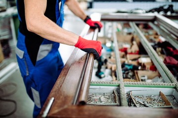 Wall Mural - Factory for aluminum and PVC windows and doors production. Manual worker assembling PVC windows and doors.