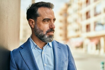 Wall Mural - Middle age businessman smiling happy standing at the city.