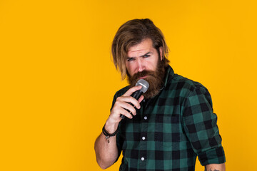 Wall Mural - singing in karaoke. mature hipster with beard sing song. brutal caucasian guy with microphone. bearded man. concept of music. he is rock star. brutal stylish singer