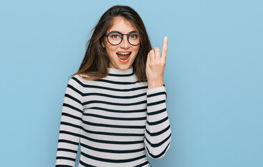 Poster - Young beautiful teen girl wearing casual clothes and glasses pointing finger up with successful idea. exited and happy. number one.