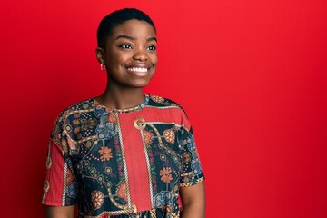 Sticker - Young african american woman wearing african style looking away to side with smile on face, natural expression. laughing confident.