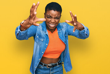 Canvas Print - Young african american woman wearing casual clothes shouting frustrated with rage, hands trying to strangle, yelling mad