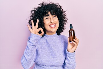 Sticker - Young middle east woman using night serum doing ok sign with fingers, smiling friendly gesturing excellent symbol